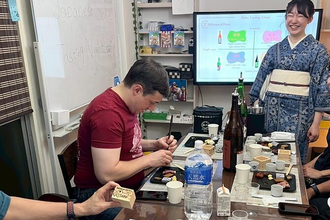 Japanese Sake Tasting and Masu Crafting Experience in Tokyo - Decorating a traditional masu cup